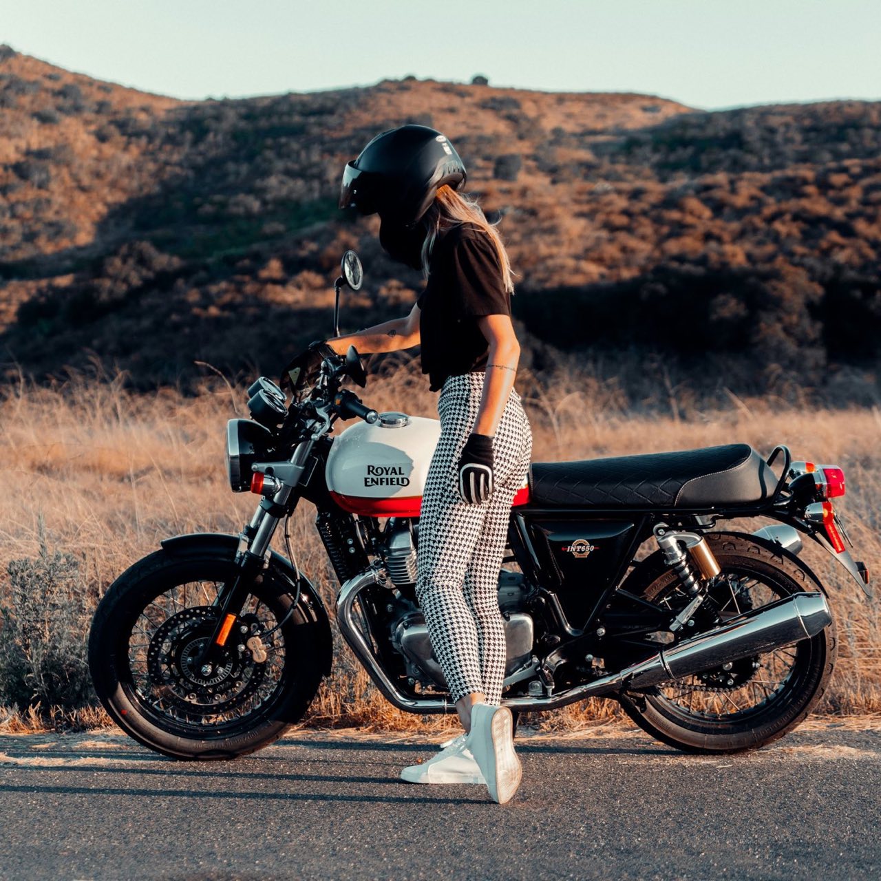 A rider on a cafe-racer motorcycle at golden hour